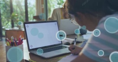 Animation of data processing, 6g icons over caucasian girl writing by laptop at desk. Digital composite, multiple exposure, education, speed, modern, e-learning, internet, technology.