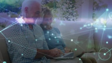 Üst düzey beyaz çiftlerin dizüstü bilgisayar kullanarak ışık yollarıyla bağlantı ağının animasyonu. Küresel teknoloji, bağlantılar ve dijital arayüz konsepti dijital olarak oluşturulmuş video.