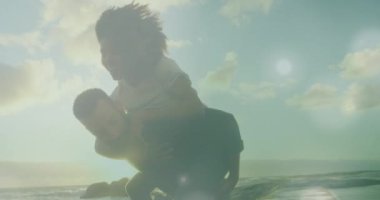 Animation of light spots over biracial couple at beach. Holidays and digital interface concept digitally generated video.