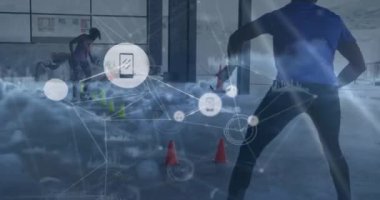 Animation of network of digital icons and clouds over african american male soccer player practicing. Global networking and sports technology concept