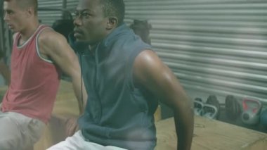 Spor salonundaki kutulara triseps bandıran çok ırklı adamların üzerindeki mercek fişeklerinin canlandırılması. Dijital kompozit, çoklu pozlama, birliktelik, fitness, spor, egzersiz, spor ve aktif yaşam tarzı konsepti.