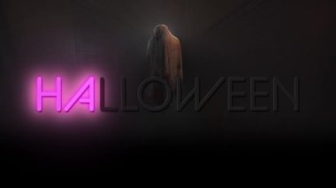 Animation of halloween text over ghost on black background. Halloween, tradition and celebration concept digitally generated video.