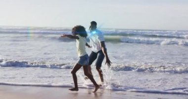 Afrika kökenli Amerikalı bir adam ve kızının kumsaldaki ışık izlerinin canlandırması. Yaşam tarzı ve boş zaman konsepti dijital olarak oluşturulmuş video.