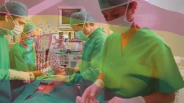 Animation of flag of spain over diverse surgeons with face masks. Global medicine, patriotism and digital interface concept digitally generated video.