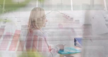Animation of caucasian businesswoman working at desk over time lapse of people and graphs. Digital composite, multiple exposure, entrepreneur, report, profession and technology concept.