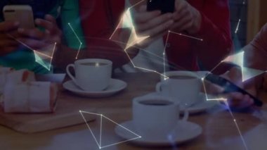 Animation of happy multiracial young friends using smart phone while having coffee. Globe, togetherness, leisure, friendship, global communications, technology.
