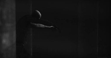 Image of scary zombie mummy walking in dark crypt room, in black and white. Halloween fear, horror and suspense concept digitally generated image.