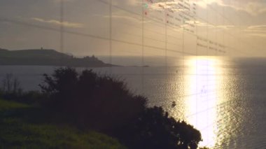 Animation of multiple graphs on grid pattern moving over scenic view of sea against sky at sunset. Digital composite, multiple exposure, database, report, nature and scenery concept.