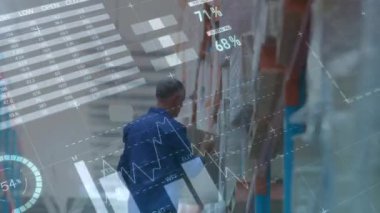 Animation of statistical data processing over caucasian male worker carrying a box at warehouse. Logistics business and technology concept