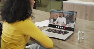 Animation of biracial woman having video call on laptop. Business, communication and working in office with technology concept.