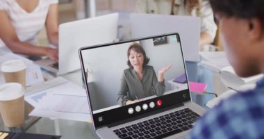 Animation of biracial man having video call on laptop. Business, communication and working in office with technology concept.