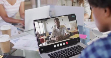 Animation of biracial man having video call on laptop. Business, communication and working in office with technology concept.