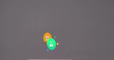 Animation of colorful icons over laptop on desk. Global social media, icons and digital interface concept digitally generated video.