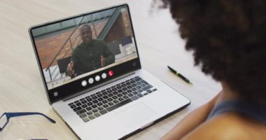 Animation of african american woman having video call on laptop. Business, communication and working in office with technology concept.