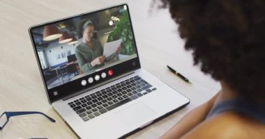 Animation of african american woman having video call on laptop. Business, communication and working in office with technology concept.