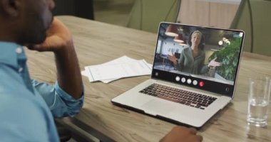 Video of afrcian american man having video call on laptop. Business, communication and working in office with technology concept.