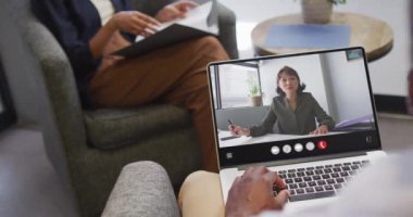 Animation of african american man having video call on laptop. Business, communication and working in office with technology concept.
