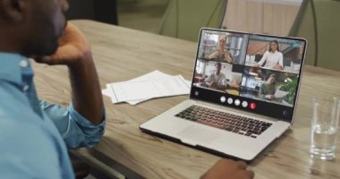 Video of afrcian american man having video call on laptop. Business, communication and working in office with technology concept.