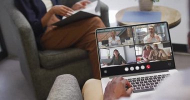 Animation of african american man having video call on laptop. Business, communication and working in office with technology concept.