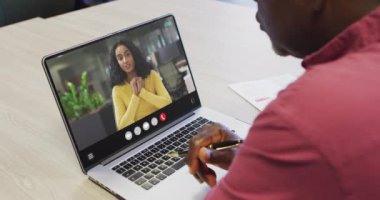 Animation of african american man having video call on laptop. Business, communication and working in office with technology concept.