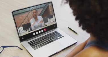 Animation of african american woman having video call on laptop. Business, communication and working in office with technology concept.