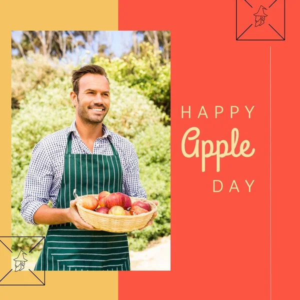 Composition of happy apple day text over caucasian man holding basket of apples. National apple day and celebration concept digitally generated image.