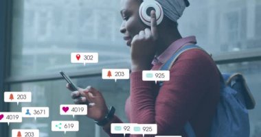 Animation of social media icons with growing numbers over african american woman using smartphone. Global social media, technology and digital interface concept digitally generated video.