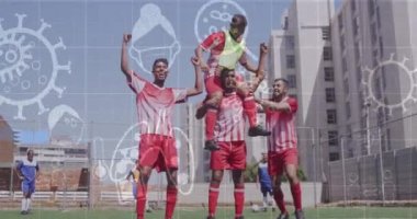 Animation of coronavirus cells, sanitizer, mask icons over players screaming and celebrating victory. Digital composite, pandemic, covid, soccer, sport, togetherness, winning and competition.