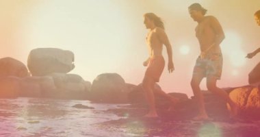 Sahilde koşan beyaz adamların üzerinde parlayan noktaların animasyonu. Yaşam tarzı ve boş zaman konsepti dijital olarak oluşturulmuş video.