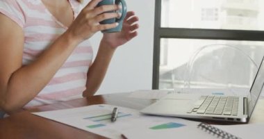 Masada çalışırken kahve içen beyaz bir kadının üzerinde koronavirüs hücrelerinin canlandırılması. Dijital bileşik, çoklu maruz kalma, covid, sağlık, salgın, hastalık, içki, evden çalışma.