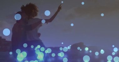 Sahildeki Afrikalı Amerikalı çiftin üzerindeki ışık noktalarının animasyonu. Yaşam tarzı ve boş zaman konsepti dijital olarak oluşturulmuş video.