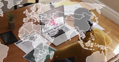 Animation of world map over african american woman having a video call on laptop at home. Global networking and business technology concept