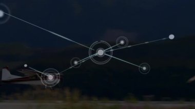 Animation of network of connections over plane landing on the runway at an airport. Global networking and aviation business technology concept