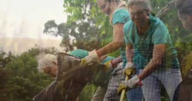 Animation of grass over diverse people cleaning in forest. Global ecology, lifestyle and nature concept digitally generated video.