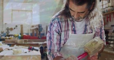 Kafkas erkek marangozun atölyede çalışmasının veri işleme animasyonu. Küresel çalışma ve dijital arayüz konsepti dijital olarak oluşturulmuş video.