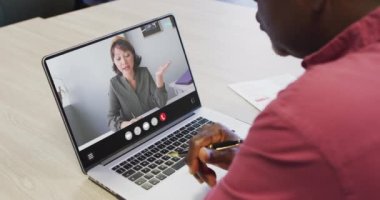 African american man using laptop for video call, with business colleague on screen. Business communication technology and remote home working, digital composite video.