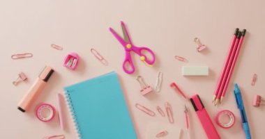 Video of composition with school equipment on pink surface. School equipment, tools, learning and education concept.