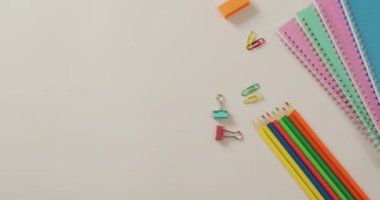 Video of composition of school items on white surface with copy space. School equipment, tools, learning and education concept.