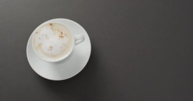 Video of white cup of coffee with milk over black background. Coffee, refreshment and beverages.