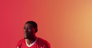 Afrika kökenli Amerikalı erkek futbolcu, kafası neon pembe ışıkta futbola dönüyor. Spor, hareket, eğitim ve aktif yaşam tarzı kavramı.
