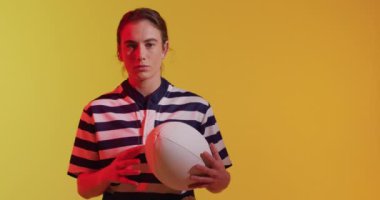 Kafkas kadın rugby oyuncusunun portresi neon ışıklı rugby topu ile. Spor, hareket, eğitim ve aktif yaşam tarzı kavramı.