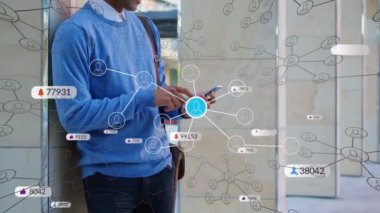 Açık havada akıllı telefon kullanan Hintli adama karşı çoklu sosyal medya ikonlarının animasyonu. Sosyal medya ağı ve iş teknolojisi kavramı