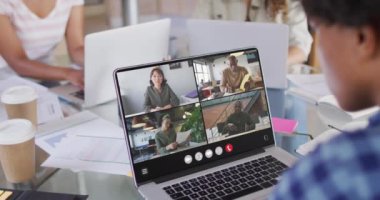 African american woman using laptop for video call, with diverse business colleagues on screen. Business communication technology and remote home working, digital composite video.