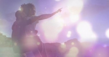 Sahildeki Afrikalı Amerikalı çiftin üzerindeki ışık noktalarının animasyonu. Boş zaman ve tatil kavramı dijital olarak oluşturulmuş video.