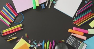 Video of frame of colorful crayons and school tools on grey surface with copy space. School equipment, tools, learning and education concept.