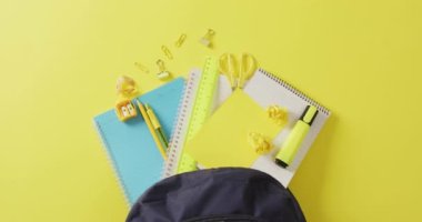 Video of blue and yellow school accessories in black case on yellow surface. School equipment, tools, learning and education concept.
