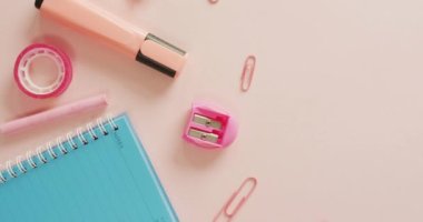 Video of composition with school equipment on pink surface. School equipment, tools, learning and education concept.