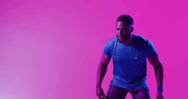 Başarılı Afrikalı Amerikalı erkek tenisçinin neon pembe yıldırımla topa vuruşunun videosu. Spor, hareket, fitness ve aktif yaşam tarzı konsepti.