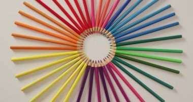 Video of central composition with colorful crayons on white surface. School equipment, tools, learning and creativity concept.