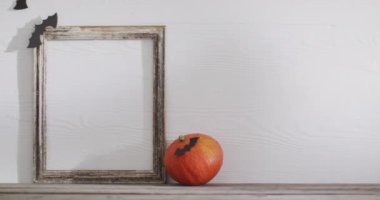 Video of frame with copy space, halloween decorations and pumpkin on white background. Halloween, autumn, tradition and celebration concept.